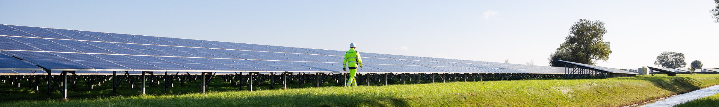 Hombre caminando junto a un panel solar